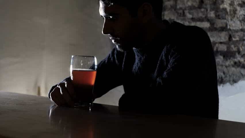 A depressed man drinking alcohol